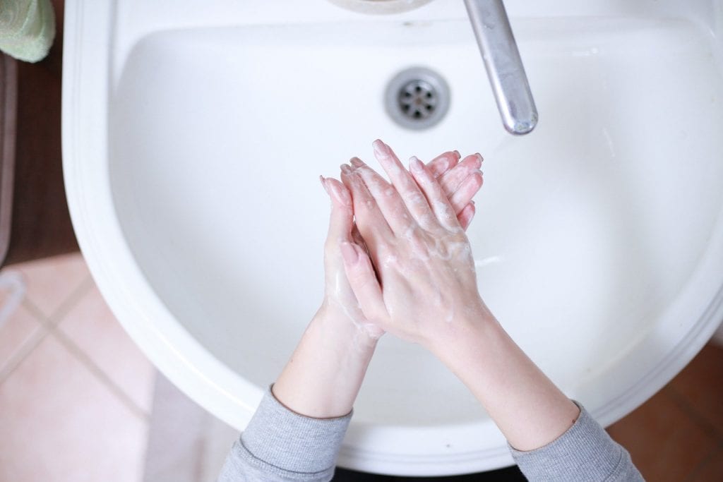 woman washing hands at sink