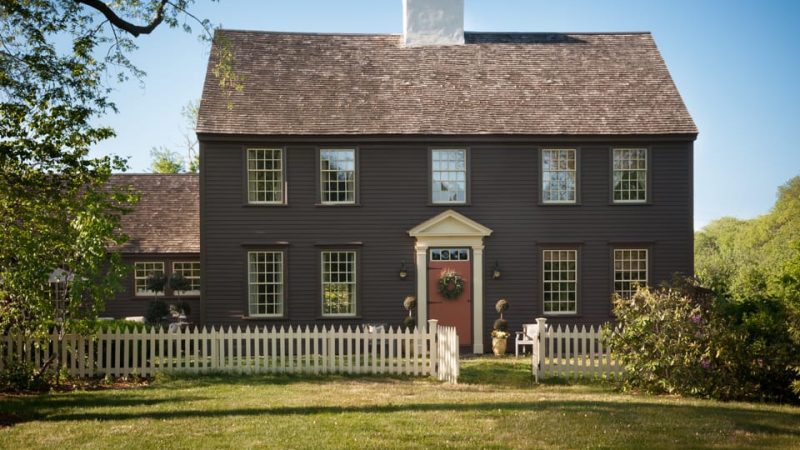 Historic home in Ipswich, MA, professional painted and restored with a brown exterior and cream window trim & fence
